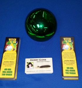 The Witch of Zal bookmarks, a green crystal ball, and business cards for Kerry Gans